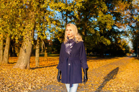 sad woman with a headache outdoors in autumnの写真素材