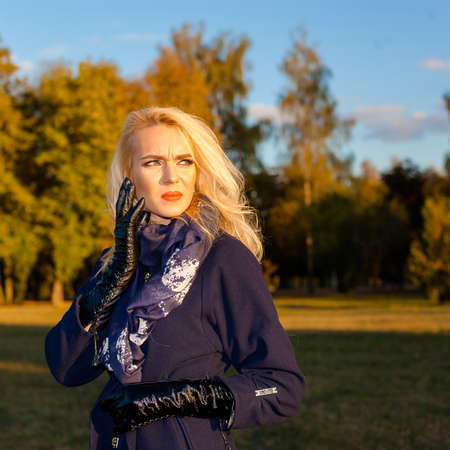 sad woman with a headache outdoors in autumnの写真素材