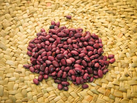 Closeup of a grain of red bean seeds. The texture of the legumes. Close up red beans on whith...