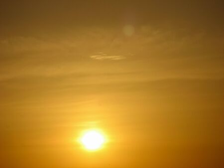  Sunset sky abstract background. Yellow sunset sky over the sea. Golden time of sky at sunset - sunrise time in summer season. Warm color sky  yellow. White space for text.の写真素材