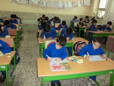 Elementary school boys  Gilan Iran. One of the primary school boys in Rasht, Guilan province, Iran.  Students are wearing school uniforms. Students are busy writing on paper.のeditorial素材
