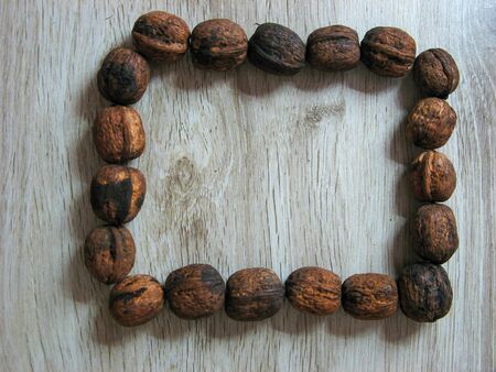 Square box with walnuts on wooden background. Walnuts is a healthy vegetarian protein nutritious food. Walnuts with space for text. Copy space.の写真素材
