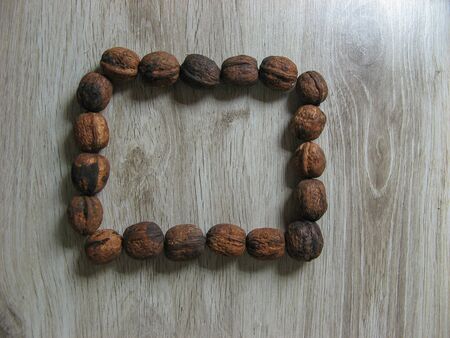Square box with walnuts on wooden background. Walnuts is a healthy vegetarian protein nutritious food. Walnuts with space for text. Copy space.の写真素材