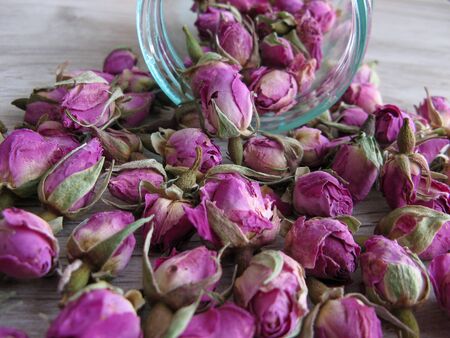 Pink Dried Rose Buds (Herbal Tea) in glass bottle on wooden background.. Reduced symptoms of depression, calmed nerves,increased circulation and improved digestion.  Antioxidant Properties of Dry Rose Tea. Closeup.

の写真素材