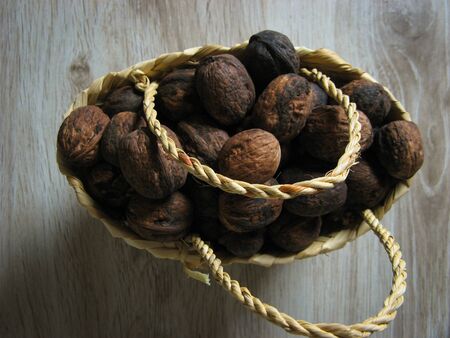 The whole walnuts are  into a wicker basket  on wooden background. Close up. Healthy organic food concept. Vegetarian food concept. Top view.

の写真素材