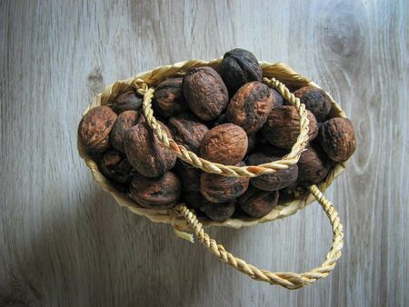 Fresh organic walnuts are  into a wicker basket  on wooden background. Close up. Healthy organic food concept. Vegetarian food concept. Top view.の写真素材