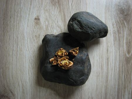 Walnuts broken on a black stone on a wooden table. Close up. concept. の写真素材