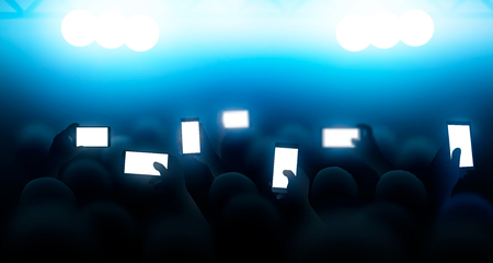 A crowd of people shooting a concert on the phones. Vector illustrationのイラスト素材