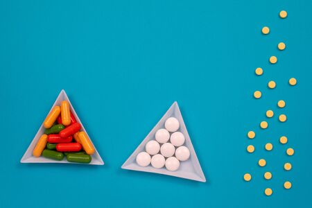 Multicolored pills are scattered on the table. Top view with copy space, flat lay.