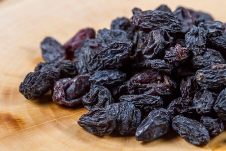 Uzbek blue raisins closeup on a wooden table. Baking ingredients. Healthly food.の写真素材