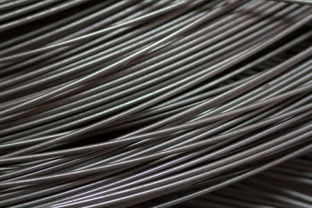 Stainless steel wire in production workshop or construction site. Close-up of wire rollers for...