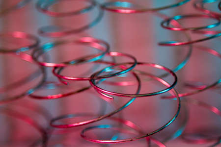 Production of independent springs for mattresses. Independent spring blocks on pink background....