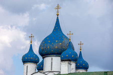 View of the Cathedral of the Nativity of the Blessed Virgin in the Suzdal Kremlin. Blue domes with gilded crosses and stars. Religion concept. Suzdal, Vladimir region, Russia - SEPTEMBER 12, 2021のeditorial素材