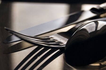 close-up of silver spoon, fork and knife under an afternoon lightの写真素材