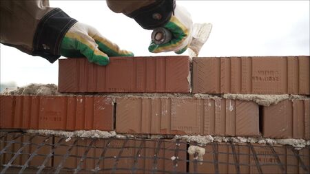Work with decorative stone. Masonry brick wall with meshの写真素材