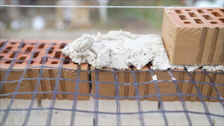 Work with decorative stone. Masonry brick wall with meshの写真素材