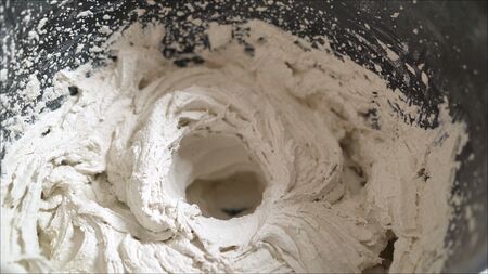 White mortar in a black bucket. trowel with bucket of filler isolated on white backgroundの写真素材