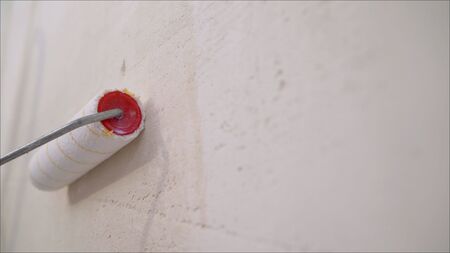 Roller Brush Painting, Worker painting on roller brush for protection. Wall paint roller.の写真素材