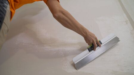 Worker plastering a wall with a spatula.. work aligns with a spatulaの写真素材