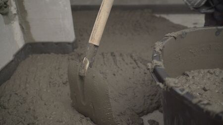 knead the solution with a mixer in a bucket of cement and sand. Bucket with a solutionの写真素材