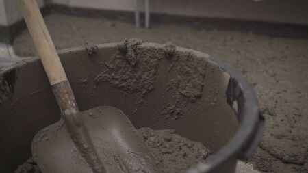 Bucket with mortar at the construction site. Black bucket with mortar for filling the floor.
