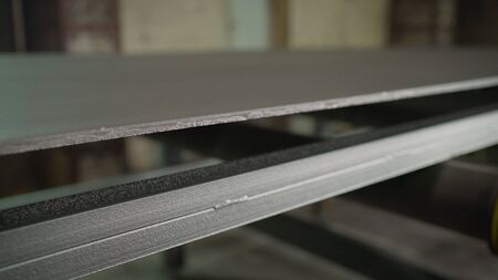 Metal sheet on the conveyor. Painting large metal sheets in a factory. Continuous sheet of metallic...