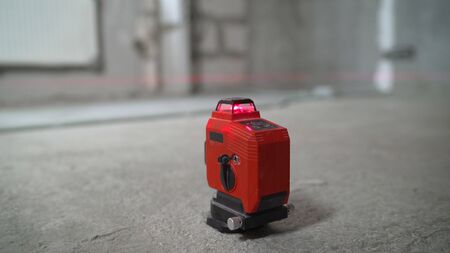 Laser level and concrete walls and floor. Apartment renovation. Laser level at work.