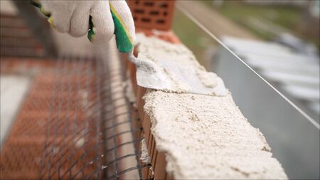 Profesional worker builds an expensive red brick house. Laying of red bricksの写真素材