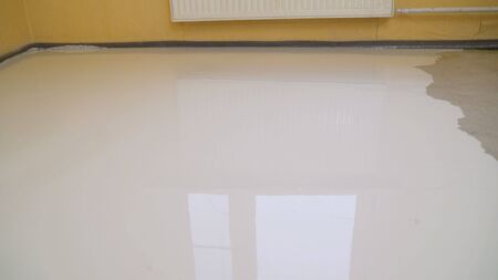 Self-filling floor. Floor leveling. Filling the floor with a self-leveling compoundの写真素材