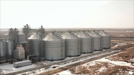 Aerial view of drone on a large granary in a field on a background of a sunset. Large aluminum...