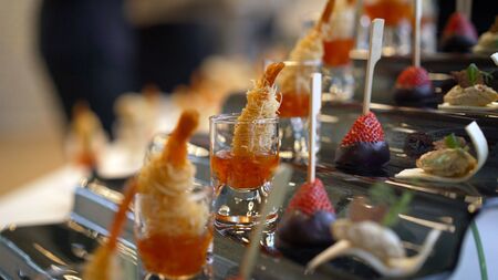 Catering. The waiter lays out snacks. off-premise catering - waitresses put fruit canapes on buffet...