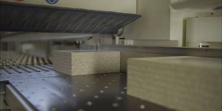 Worker with boards in a factory. The young master folds the board. Dvp production