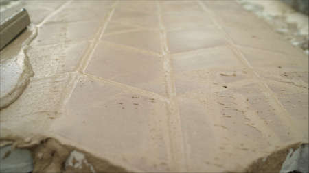 Worker levels concrete with a spatula, hands pour poured concrete. Paving slabs with mortar.
