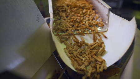The process of making crackers. Cracker production. Croutons on the conveyor. Bread products on a conveyor line, in a food factory or in a factory with equipment.の写真素材