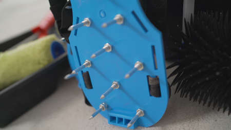 Walking shoes with needle roller and wet screed. Needle roller for self-leveling floor. concrete floor. on the horizon. close-up. needle roller to remove air bubbles.の写真素材