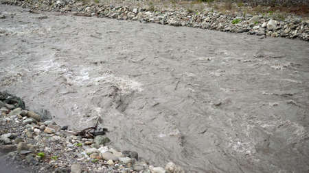 Mountain river in Caucasus. Mountain dirty river flows fast.