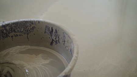 Mixing the building mixture in a bucket with a mixer. Bricklayer mixing cement in bucket. Concrete...