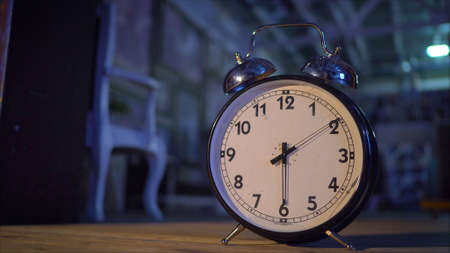 Retro alarm clock on table. Vintage style sepia photo. Big alarm clockの写真素材