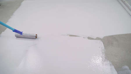 Contract painter painting garage floor to speed up selling of home. Paint the floor with a roller.の写真素材