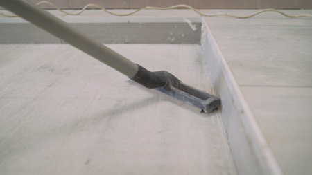 A worker removes dust from a construction site with a vacuum cleaner. A man using an industrial vacuum cleaner. Industrial vacuum cleaner at work.の写真素材