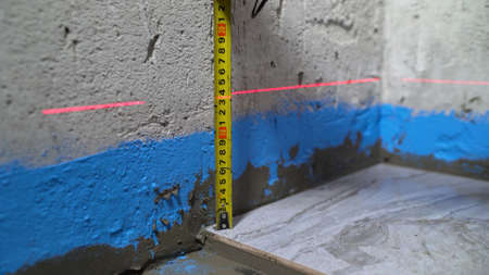 Checking the tiles in the bathroom. Quality control when laying ceramic tiles on the floor. The...
