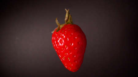 Ripe fresh strawberry on black background. Hanging strawberries close-up on a black background.の写真素材