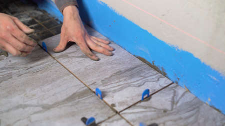 Laying the floor with ceramic tiles. Floor repair. Ceramic tiles. The tiler is laying ceramic tiles...