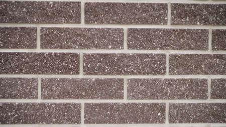 Close-up of a seam in a brick wall. Brown brick wall with cement joints close up. Brown brick wall.