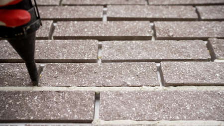 Close-up of a seam in a brick wall. Brown brick wall with cement joints close up. Brown brick wall.