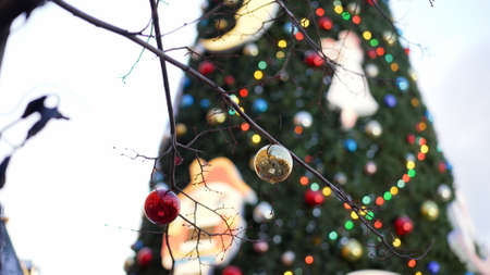 Street Christmas decorations. Tree branches decorated with gold and red Christmas balls against the...