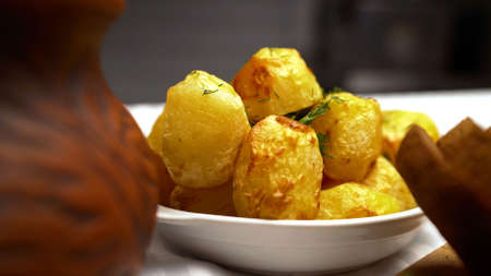 Appetizing round fried potatoes. Round whole potatoes cooked in the oven. Golden fried potatoes without skins.の写真素材
