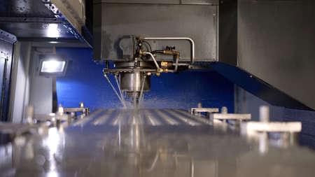 The process of drilling metal with water supply. Metalworking machine at work. Cutting a thread in a...