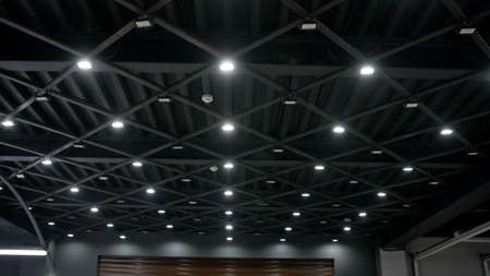 Stylish black ceiling with lamps in a car showroom. Modern ceiling solution in black style. Ceiling in the showroom and car detailing.の写真素材