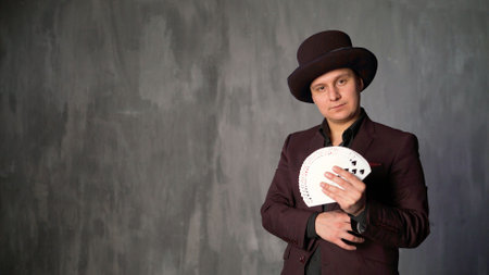 A magician performing a card trick. Playing cards in the hands of a magician. The magician changes cards, close-up.の写真素材